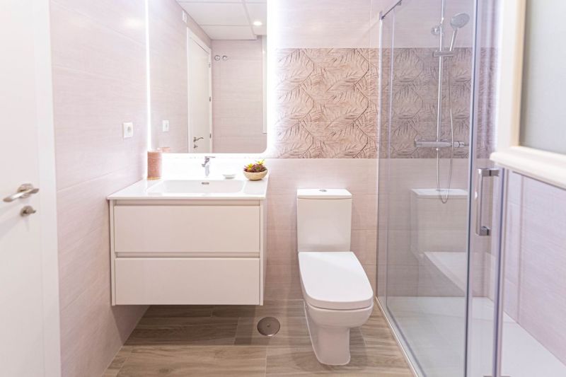 Badezimmer in einer Ferienwohnung mit Holzboden und Duschkabine.