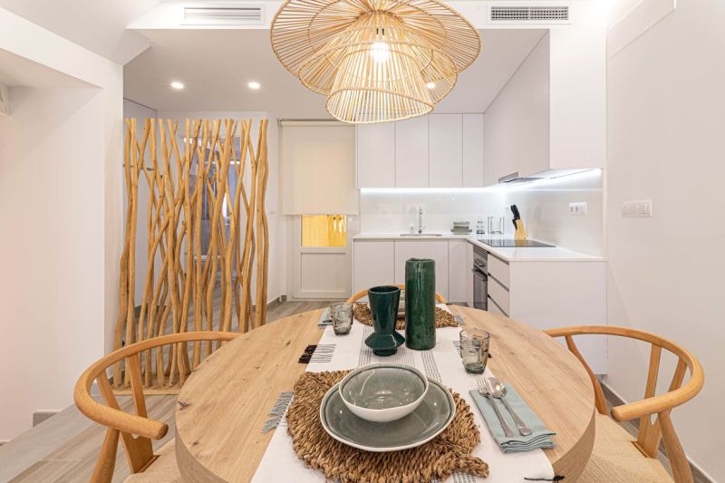 Essbereich im Ferienapartment mit Holzelementen und Deckenleuchte.