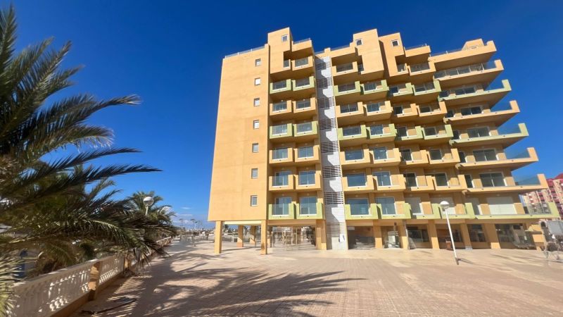 Ferienwohnung in La Manga del Mar Menor mit Palmen und klarem Himmel.