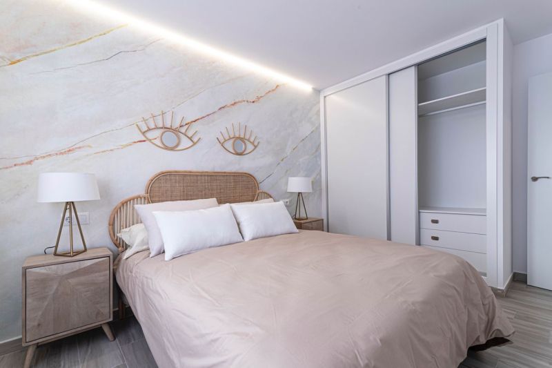 Ferienwohnung mit dekorativen Elementen, Doppelbett und Holzboden.
