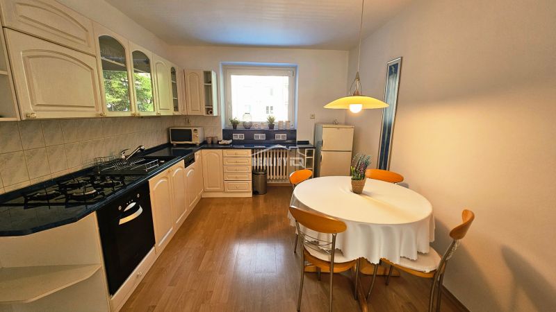 Helle Küche in einer 2-Zimmer-Wohnung mit Gasherd und Holzboden.