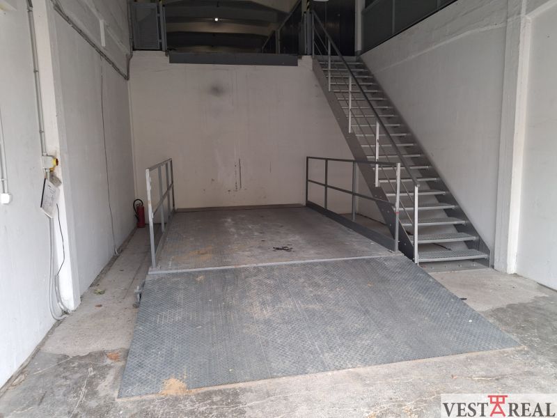 Lagerhäuser und Hallen mit einer Metallplattform und Treppe, weiße Wände, industrieller Look.