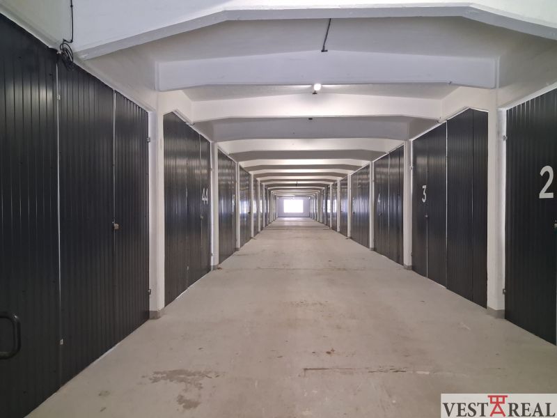 Langer Flur mit Garagenboxen in Lagern und Hallen.