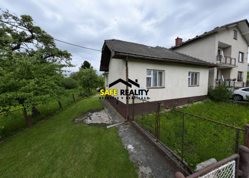 Ein Einfamilienhaus in Žilina mit gepflegtem Garten und Zaun, umgeben von Natur.