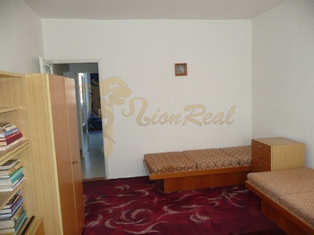 Ein Zimmer in einer 2-Zimmer-Wohnung mit einfacher Einrichtung und rotem Teppich.