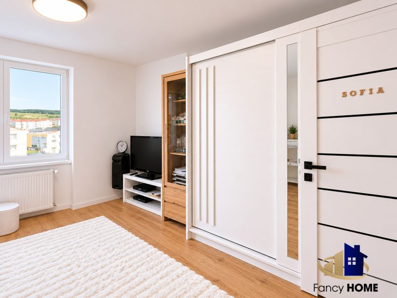 Wohnbereich in einer 2-Zimmer-Wohnung mit Holzdekorboden und Fernseher.