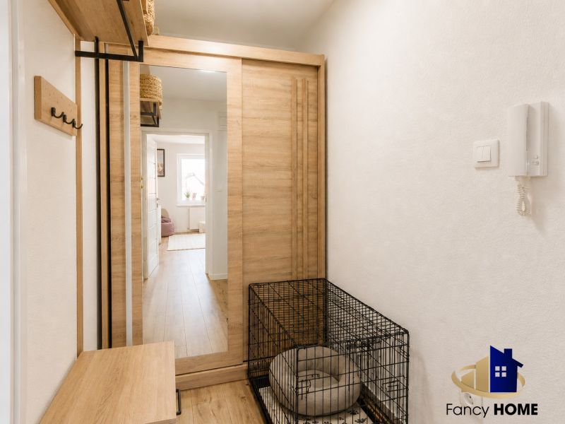 Eingangsbereich in einer 2-Zimmer-Wohnung mit dekorativem Boden und Spiegelschrank.