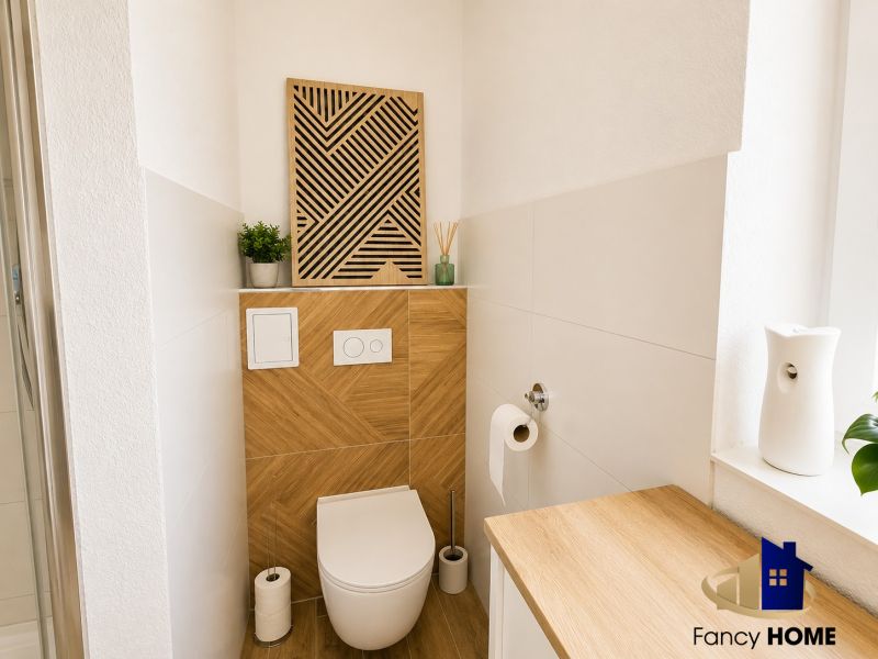 Helles Badezimmer mit Holzelementen und interessanter Wanddekoration in einer Zweizimmerwohnung.