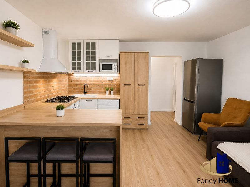 Küche in einer 2-Zimmer-Wohnung mit Ziegelverkleidung und Boden mit Holzdekor.