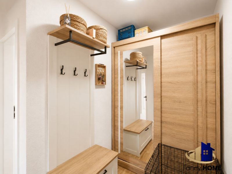Eingangsbereich in einer 2-Zimmer-Wohnung mit Holzboden und Stauraum.