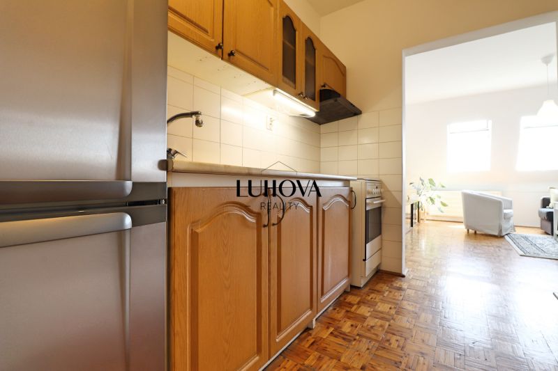 Küche mit Holzschränken in einer 2-Zimmer-Wohnung, Boden mit Holzdekor.