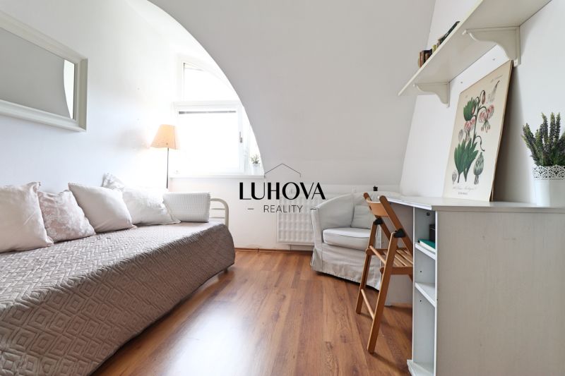 Ein Zimmer in einer 2-Zimmer-Wohnung mit einem Holzboden, einem Bett und einem Schreibtisch.