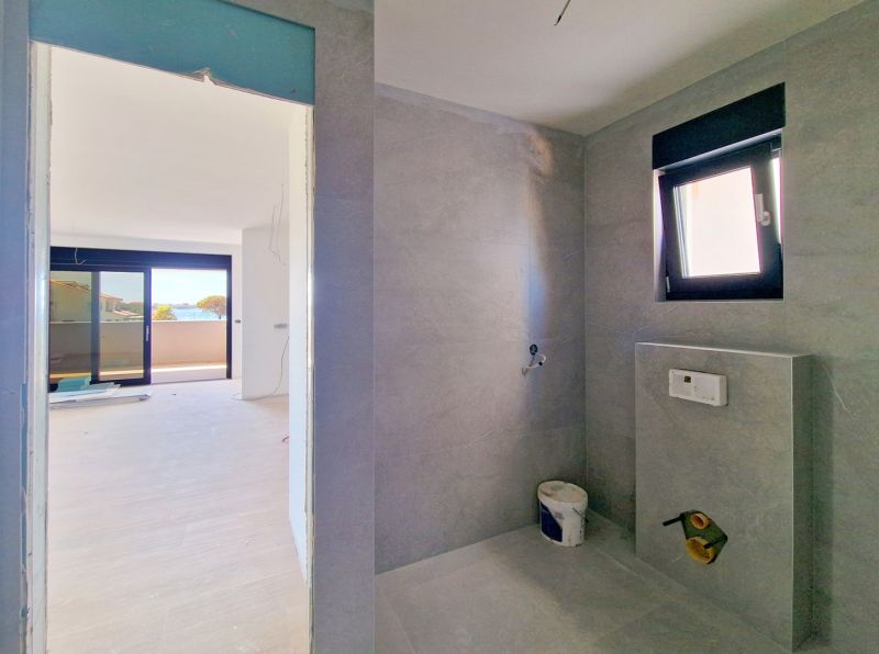 Badezimmer mit modernen Fliesen in einer 3-Zimmer-Wohnung, Blick auf die Terrasse.