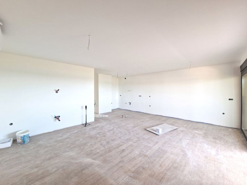 Geräumiges Zimmer einer 3-Zimmer-Wohnung mit Holzboden und großem Fenster.