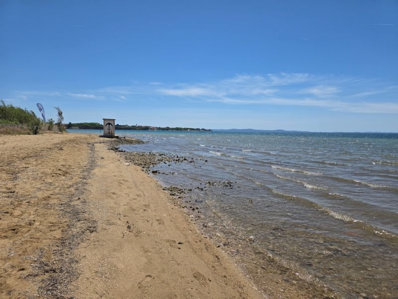 Ein Strand mit goldenem Sand und ruhigem Meer in der Stadt Privlaka.