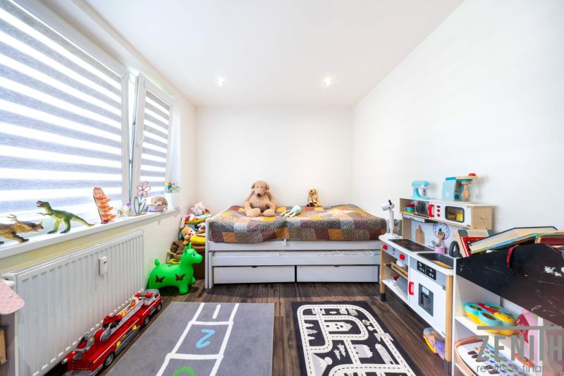 Kinderzimmer mit Spielzeug und Bett, Holzboden in einer 3-Zimmer-Wohnung.