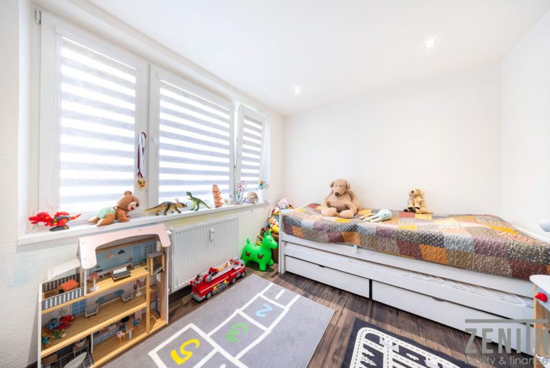 Kinderzimmer in einer 3-Zimmer-Wohnung mit Holzboden, voller Spielzeug und Teddybären.