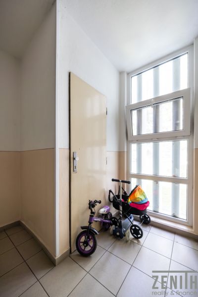 Flur mit Kinderfahrrad am Fenster und an der Tür in einer 3-Zimmer-Wohnung.