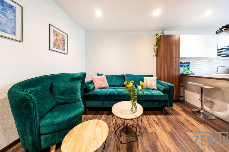 3-Zimmer-Wohnung mit Sofa, Blumen auf dem Tisch und Holzboden.