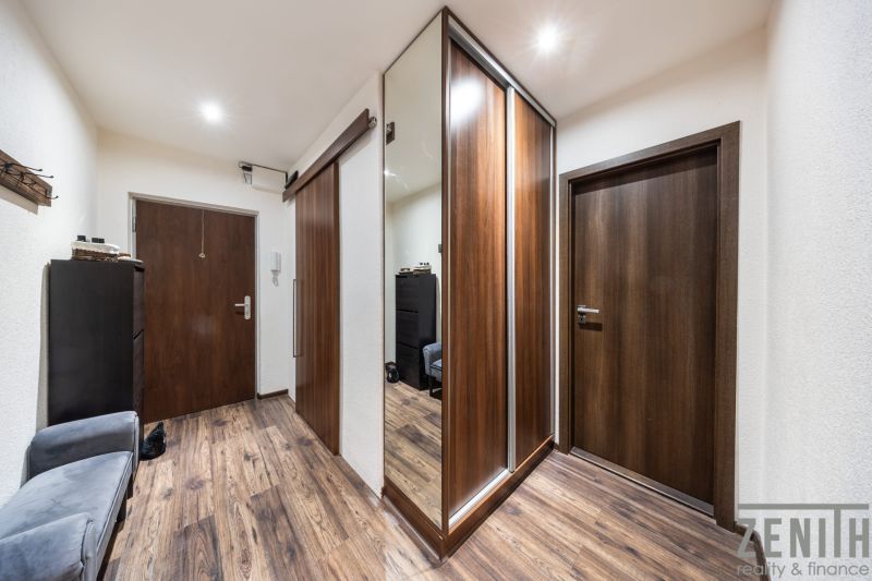Eingangsflur mit Holzboden in einer 3-Zimmer-Wohnung, Spiegelschrank und Licht.