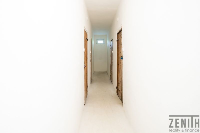Der Flur in einer 3-Zimmer-Wohnung mit weißen Wänden und Türen zu den Räumen.