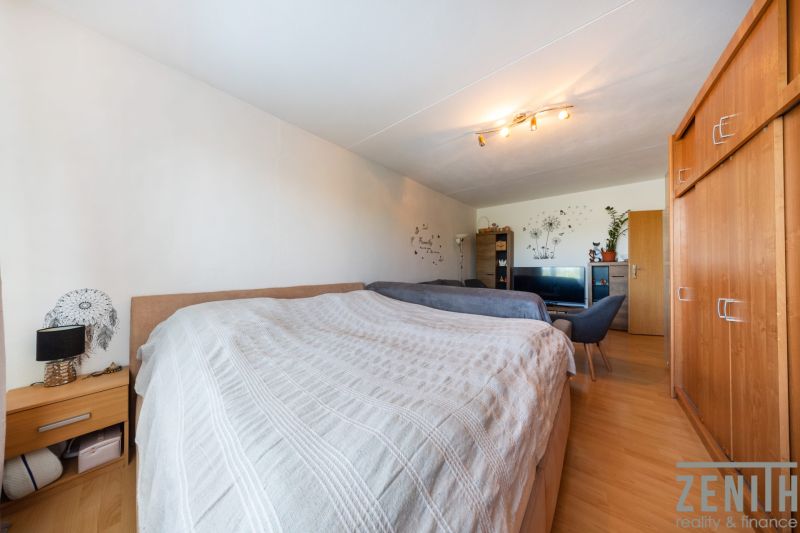 Schlafzimmer in einer 3-Zimmer-Wohnung mit Einbauschrank und Bodenbelag in Holzoptik.