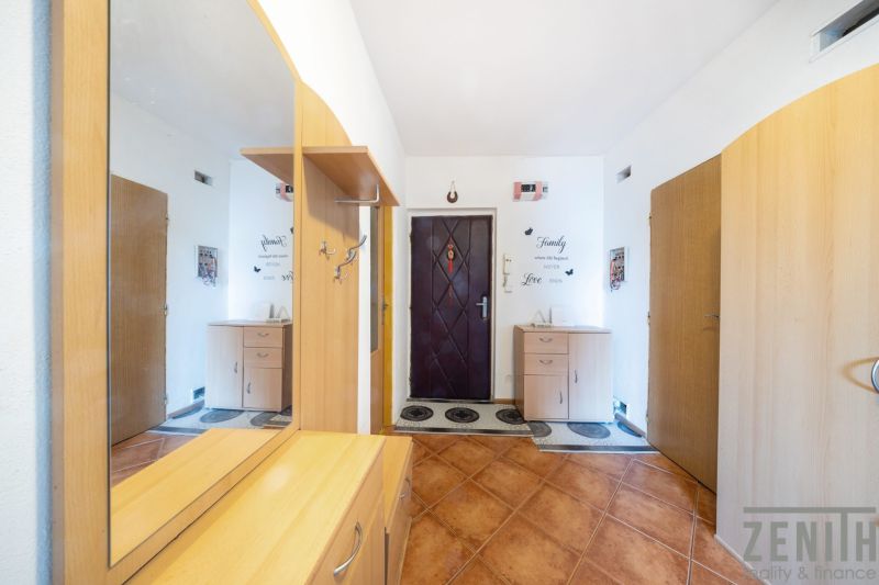 Der Flur in einer 3-Zimmer-Wohnung mit einem Boden in Holzoptik und einem Spiegel.
