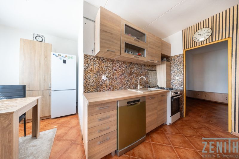 Küche in einer 3-Zimmer-Wohnung mit Holzboden und Keramikfliesen.