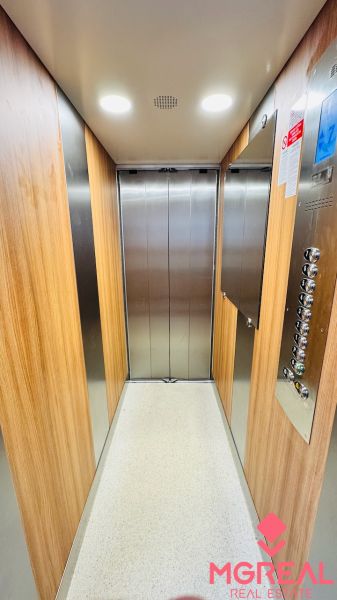 Das Innere des Aufzugs mit Holzdekor und Bedienfeld in einer Einzimmerwohnung.