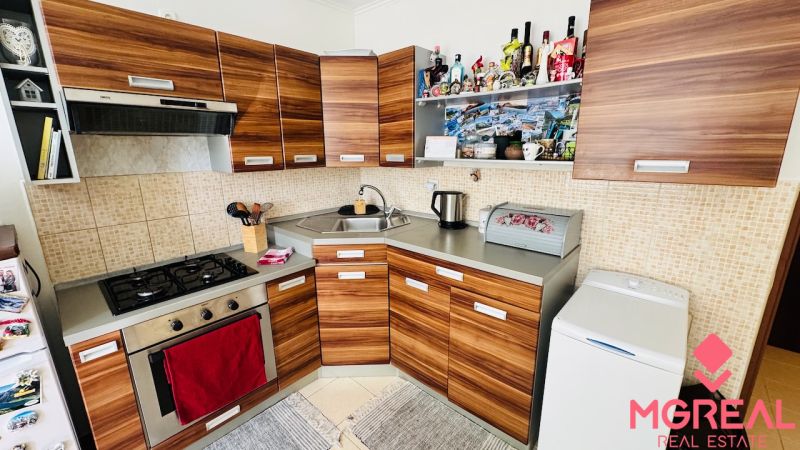 Küche in einer Einzimmerwohnung mit Holzelementen und eingebautem Herd.