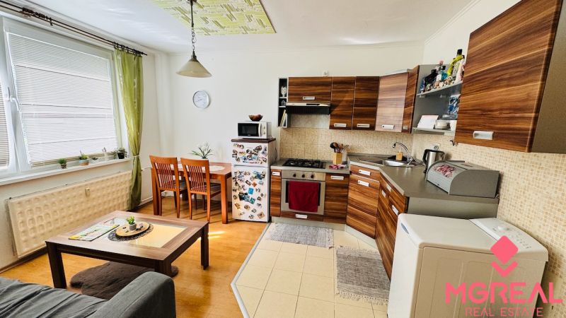 Küche mit Holzelementen und Esstisch in einer Einzimmerwohnung.
