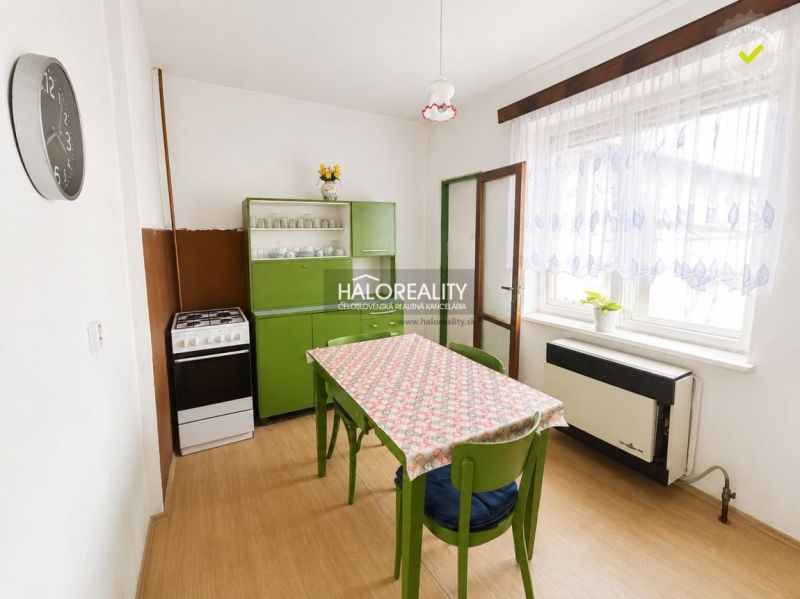 Eine Küche in einem Einfamilienhaus mit Retro-Möbeln und einem Boden mit Holzdekor.
