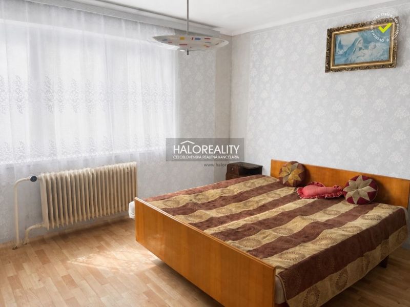 Schlafzimmer in einem Einfamilienhaus mit Holzboden und einem Heizkörper am Fenster.