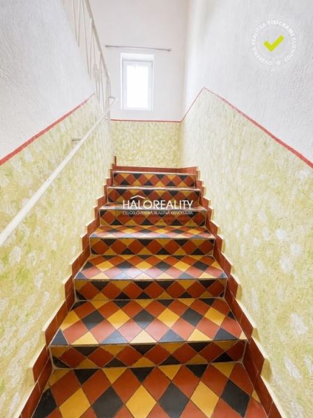 Innenraum eines Einfamilienhauses mit bunten Fliesen auf den Treppen und weißen Wänden.