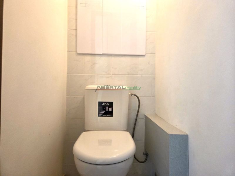Ein Badezimmer mit gefliesten Wänden in einer Einzimmerwohnung.