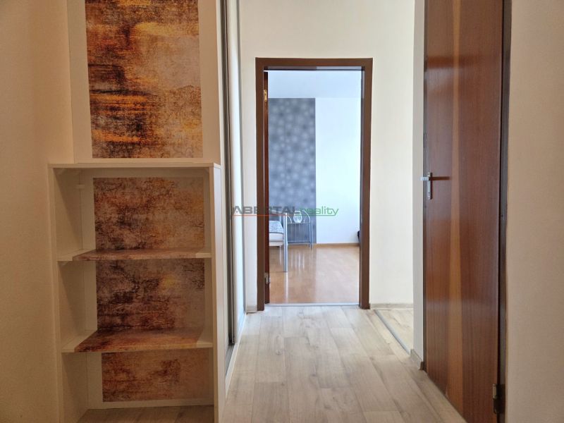 Flur mit Holzboden in einer Einzimmerwohnung. Eingang zu einem weiteren Raum.