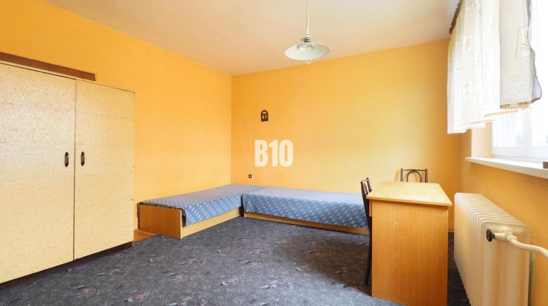 Ein Zimmer in einem Einfamilienhaus mit blauen Betten, einem Schreibtisch und einem Teppich.