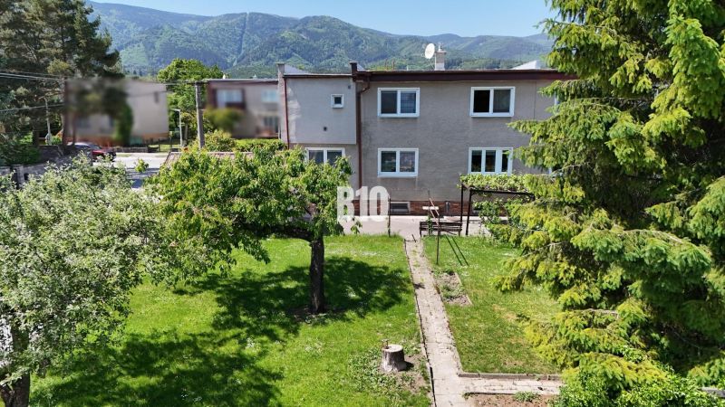 Ein Einfamilienhaus in Martin mit einem weitläufigen Garten und Bergen im Hintergrund.