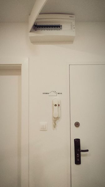Weißes Interieur mit einem elektrischen Verteilerkasten und einem Haustelefon in einer 4-Zimmer-Wohnung.