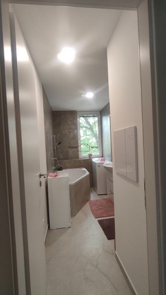 Badezimmer mit Dusche und Badewanne in einer 4-Zimmer-Wohnung, helle Fliesen und Bodenbeläge.
