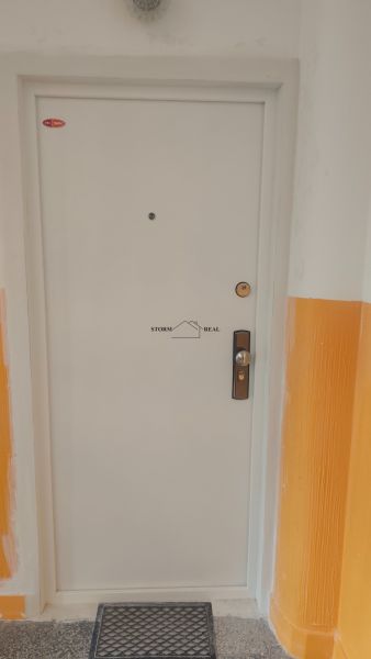 Weiße Eingangstür in einer 4-Zimmer-Wohnung mit Sicherheitsschloss.