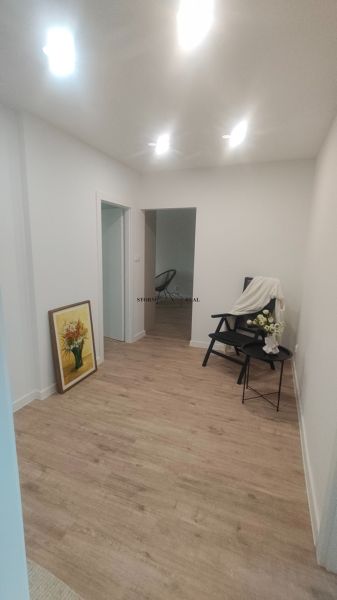 Der Flur in der 4-Zimmer-Wohnung mit einem Holzboden und einem Bild an der Wand.