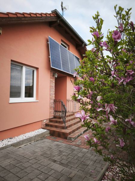 Ein Einfamilienhaus in der Hauptstraße in Martin nad Žitavou mit Solarpaneelen und einer Magnolie.