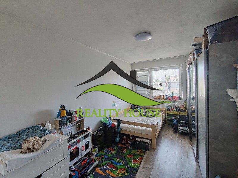 Kinderzimmer mit hellen Wänden und einem Boden in Holzoptik in einer 3-Zimmer-Wohnung.
