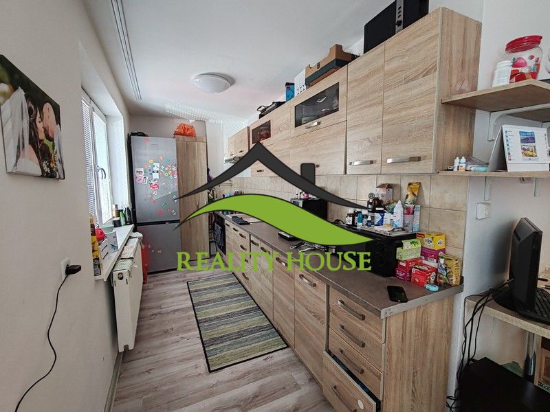 Küche mit Holzelementen in einer 3-Zimmer-Wohnung, ausgestattet mit Geräten und Stauraum.