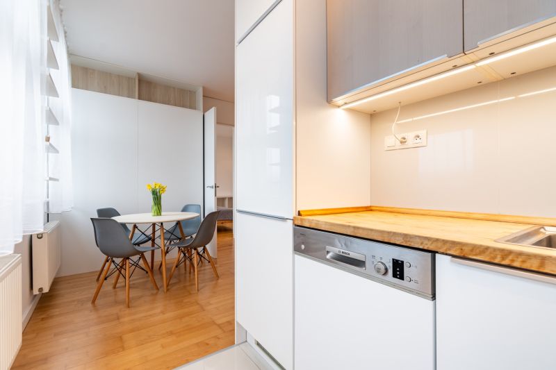 Küche mit Holzelementen, Esstisch und vier Stühlen in einer 2-Zimmer-Wohnung.