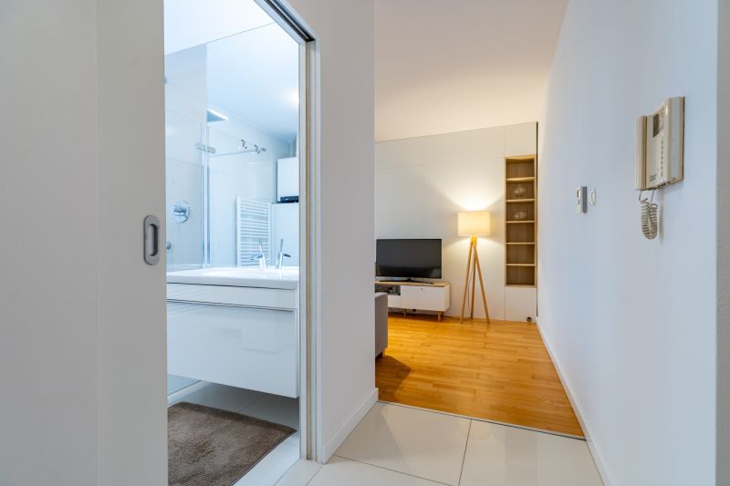 Eingang zum Badezimmer und Wohnzimmer mit Holzboden in einer 2-Zimmer-Wohnung.