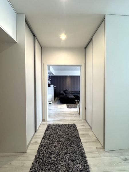 Flur mit Einbauschränken und Boden in Holzoptik in einer 4-Zimmer-Wohnung.