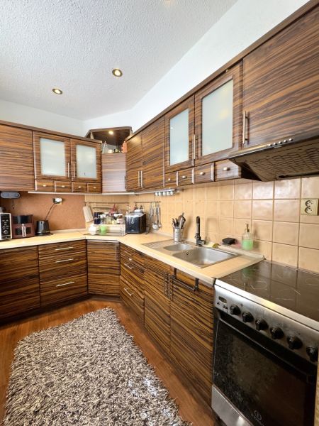 Küche in einer 4-Zimmer-Wohnung mit Holzboden und Geräten.