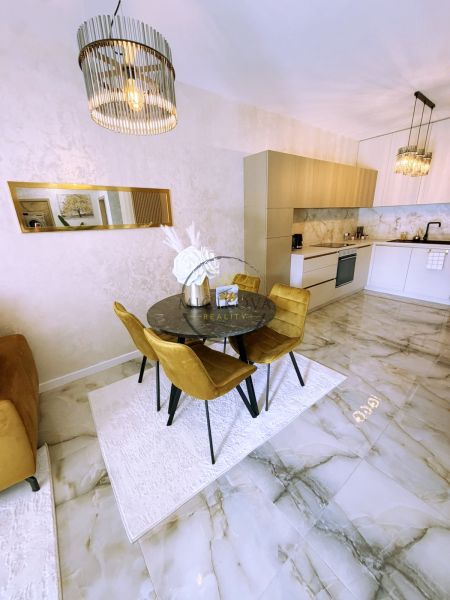 Essbereich in einer 2-Zimmer-Wohnung mit Marmorboden und eleganter Beleuchtung.